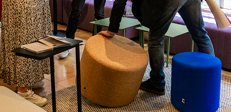 A customer inspects a Pop stool upholstered in Cork fabric at CDW23