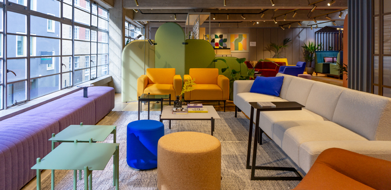 The informal lounge area in sixteen3's Bastwick Street showroom at CDW23. There's an Otto sofa, two Otto armchairs, Monsal benches, Milo tables, Pop stools and an Icarus table